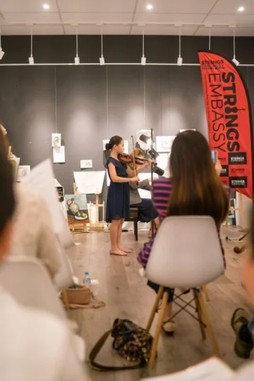 Violin performance for an audience at a Strings Embassy studio concert