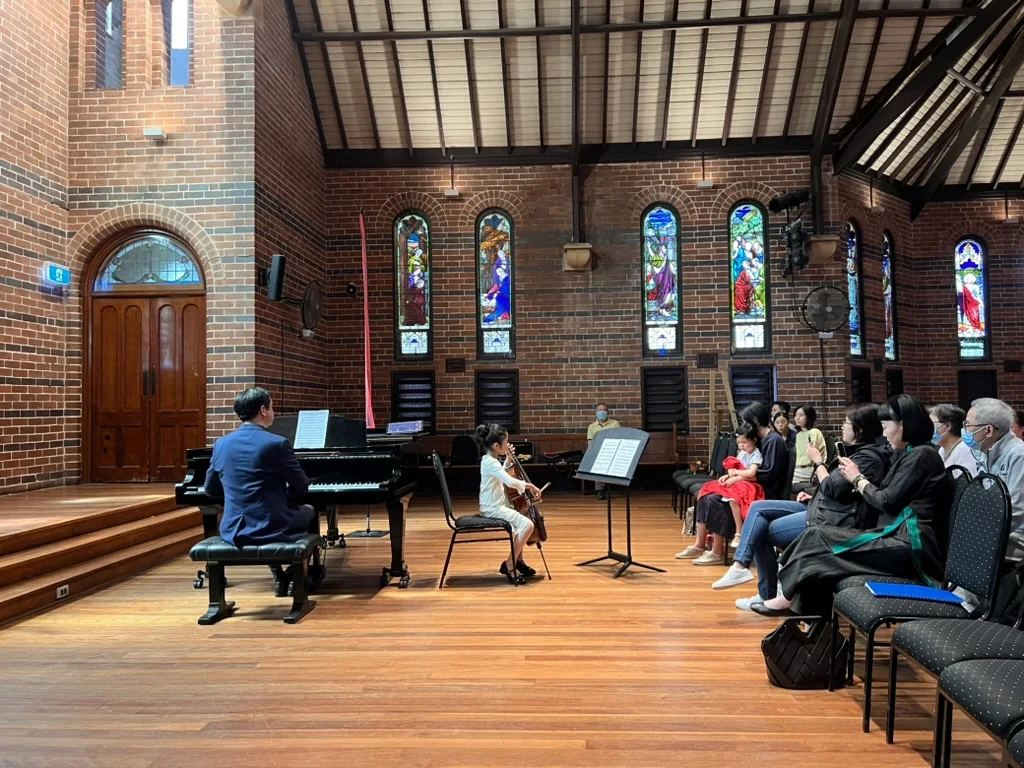 Young cellist performing with piano at a Strings Embassy student recital