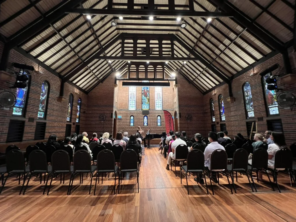 Audience gathered for a Strings Embassy violin recital in a heritage hall